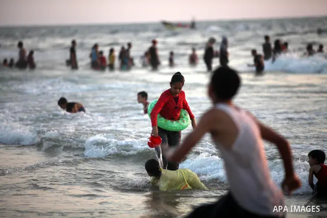Palestinians enjoy swimming in the sea at Gaza beach on 13 July 2012 in Gaza City. Photo by Majdi Fathi
