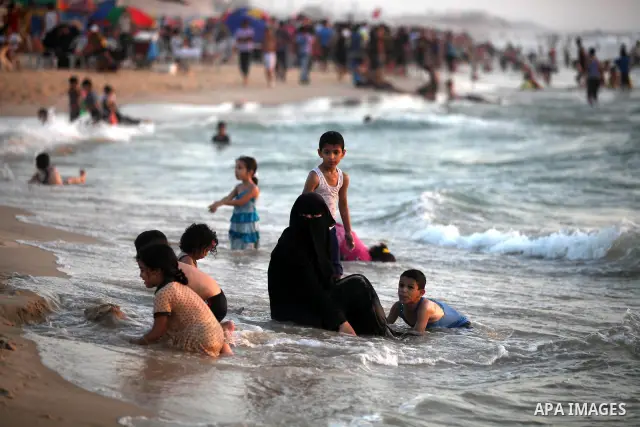 Palestinians enjoy swimming in the sea at Gaza beach on 13 July 2012 in Gaza City. Photo by Majdi Fathi