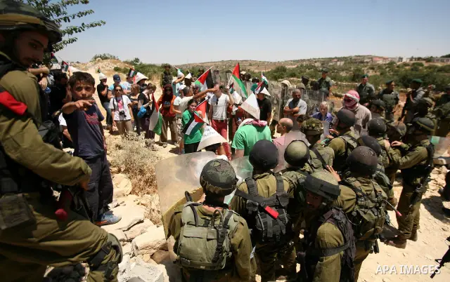 Palestinian and international demonstrators protest in the West Bank village of Susya, south Hebron, against pending demolition orders given by the Israeli Army, to demolish the village entrance, 14 July 2012. Photo by M...