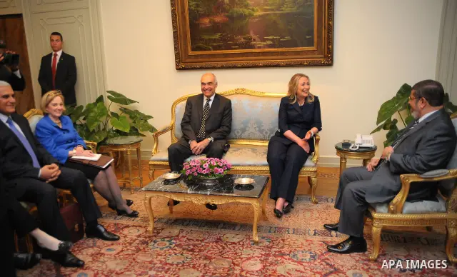 Egyptian Foreign Minister Mohammed Kamel Amr, U. S. Secretary of State Hillary Clinton, and Egyptian President Mohammed Morsi, during a photo opportunity at their meeting at the Presidential palace in Cairo, Egypt, Satur...