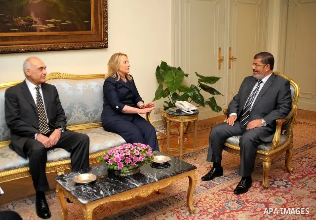 Egyptian Foreign Minister Mohammed Kamel Amr, U. S. Secretary of State Hillary Clinton, and Egyptian President Mohammed Morsi, during a photo opportunity at their meeting at the Presidential palace in Cairo, Egypt, Satur...