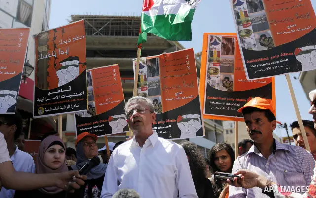 Mustafa al-Barghouthi, Secretary General of the Palestinian National Initiative speaks during a protest demanding Palestinian merchants to boycott Israeli settlement products and goods, and support national economy in th...