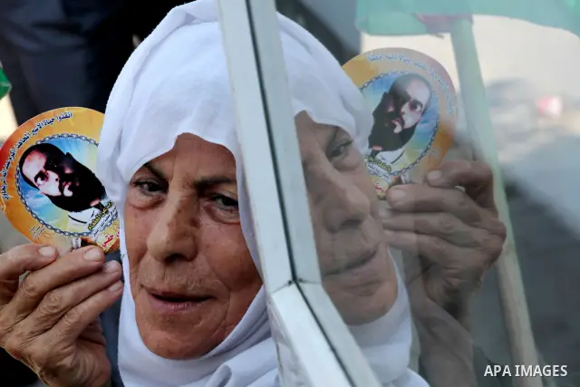 A Palestinian woman holds picture of her son during a protest calling for the release of prisoners held in Israeli jails in front of the headquarters Red Cross in Gaza City, on July.16, 2012. Photo by Ashraf Amra