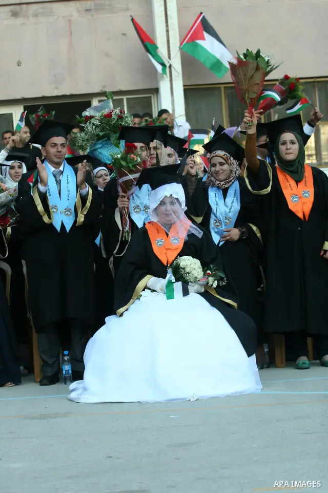Palestinian bride celebrates her marriage during graduation ceremony at Al-Quds Open University in the West Bank city of Nablus, on July 16, 2012. Photo by Nedal Eshtayah