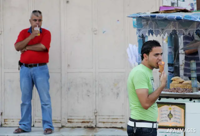 Palestinians eat ice-cream in the street during hot weather in Gaza city, July 16, 2012. The temperature of the Gaza strip reaches more than 33 degrees Celsius and 61% humidity, Gazans escape to the beach and out from th...