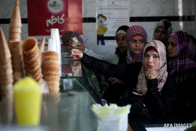 Palestinians buy ice-cream during hot weather in Gaza city, July 16, 2012. The temperature of the Gaza strip reaches more than 33 degrees Celsius and 61% humidity, Gazans escape to the beach and out from their homes duri...