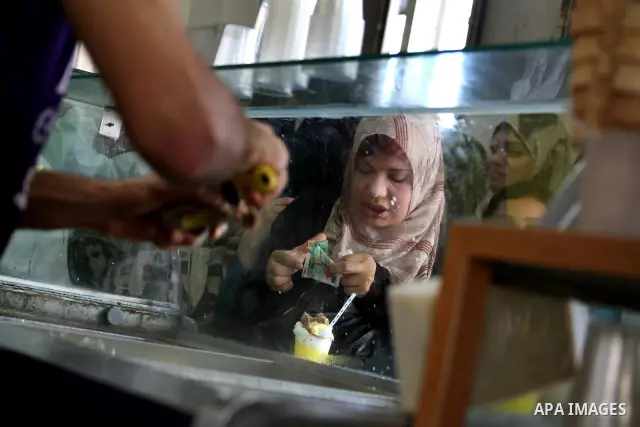 A Palestinian vendor sells ice-cream during hot weather in Gaza city, July 16, 2012. The temperature of the Gaza strip reaches more than 33 degrees Celsius and 61% humidity, Gazans escape to the beach and out from their...