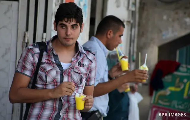 Palestinians eat ice-cream in the street during hot weather in Gaza city, July 16, 2012. The temperature of the Gaza strip reaches more than 33 degrees Celsius and 61% humidity, Gazans escape to the beach and out from th...