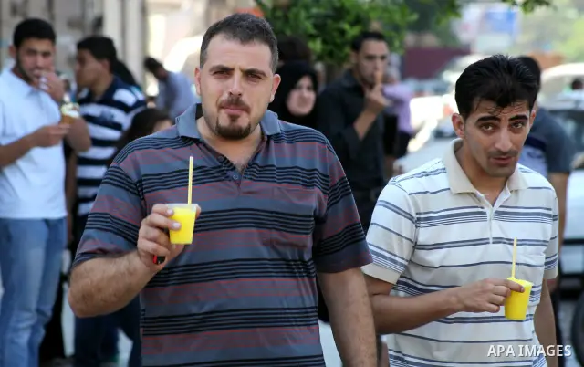 Palestinians eat ice-cream in the street during hot weather in Gaza city, July 16, 2012. The temperature of the Gaza strip reaches more than 33 degrees Celsius and 61% humidity, Gazans escape to the beach and out from th...