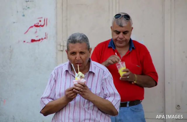 Palestinians eat ice-cream in the street during hot weather in Gaza city, July 16, 2012. The temperature of the Gaza strip reaches more than 33 degrees Celsius and 61% humidity, Gazans escape to the beach and out from th...