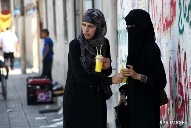Palestinians eat ice-cream in the street during hot weather in Gaza city, July 16, 2012. The temperature of the Gaza strip reaches more than 33 degrees Celsius and 61% humidity, Gazans escape to the beach and out from th...