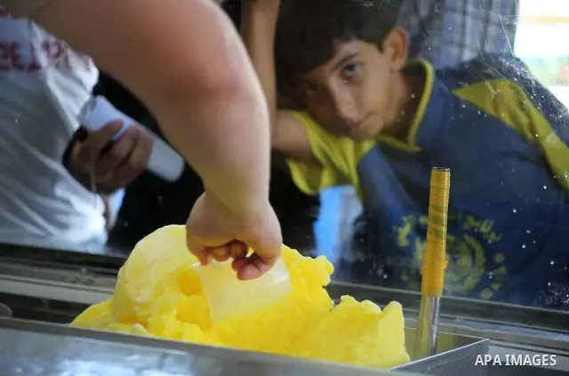 Palestinians buy ice-cream during hot weather in Gaza city, July 16, 2012. The temperature of the Gaza strip reaches more than 33 degrees Celsius and 61% humidity, Gazans escape to the beach and out from their homes duri...