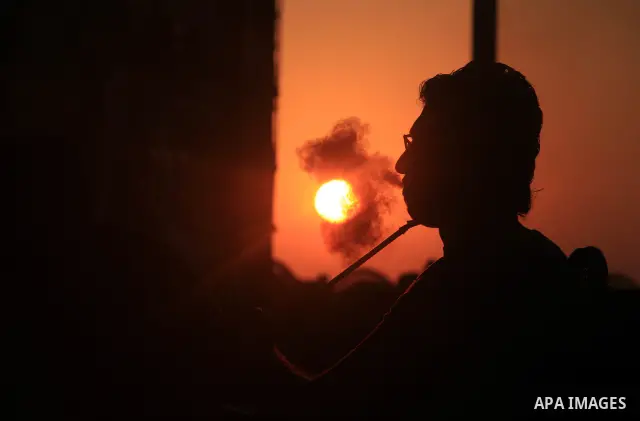A Palestinian man smokes hookah at Gaza beach during hot weather in Gaza city, July 16, 2012. The temperature of the Gaza strip reaches more than 33 degrees Celsius and 61% humidity, Gazans escape to the beach and out fr...