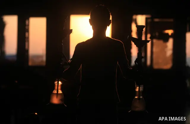 A Palestinian waiter prepares hookah at Gaza beach during hot weather in Gaza city, July 16, 2012. The temperature of the Gaza strip reaches more than 33 degrees Celsius and 61% humidity, Gazans escape to the beach and o...