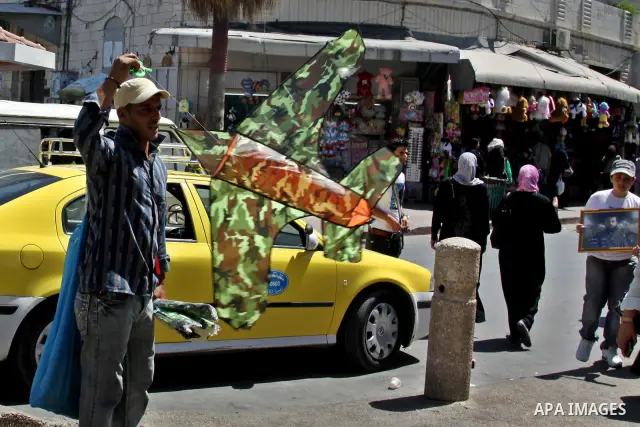 A Palestinian vendor sells kites in the street in the West Bank city of Nablus, on July 17, 2012. Photo by Nedal Eshtayah