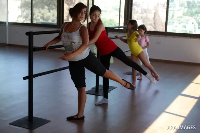 Palestinian girls lean on bars during a ballet class at the Ramallah Ballet Center dance school in the West Bank city of Ramallah July 17, 2012. The center is the first in the occupied West Bank. Photo by Issam Rimawi