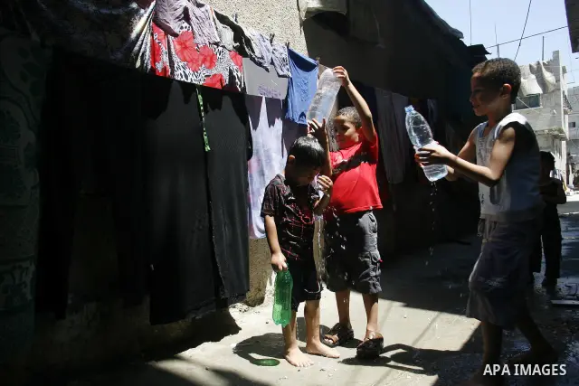Palestinian children bathe outside their home in the Rafah refugee camp in the southern Gaza Strip on July 17, 2012. The temperature of the Gaza strip reaches more than 35 degrees Celsius and 50% humidity, Gazans escape...