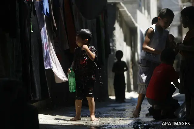 Palestinian children bathe outside their home in the Rafah refugee camp in the southern Gaza Strip on July 17, 2012. The temperature of the Gaza strip reaches more than 35 degrees Celsius and 50% humidity, Gazans escape...