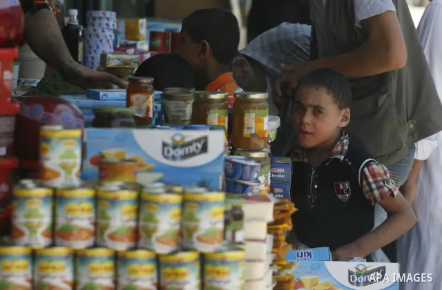 Palestinian children look at a vendor as he displays foodstuff in preparation for the holy month of Ramadan in the Rafah refugee camp in the southern Gaza Strip on July 17, 2012 . Islam's holy month of Ramadan will begin...