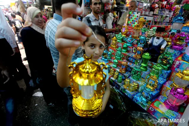 A Palestinian child Inspects toys as the vendor displays goods in preparation for the holy month of Ramadan in the Gaza city on July 17, 2012 . Islam's holy month of Ramadan will begin in few days depending on the sighti...
