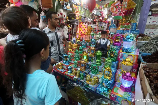 Palestinians Inspect goods as the vendor displays it in preparation for the holy month of Ramadan in the Gaza city on July 17, 2012 . Islam's holy month of Ramadan will begin in few days depending on the sighting of the...