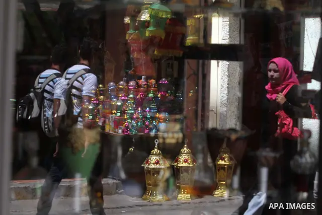 Palestinians walk in front of the shop as the vendor displays goods in preparation for the holy month of Ramadan in the Gaza city on July 17, 2012 . Islam's holy month of Ramadan will begin in few days depending on the s...