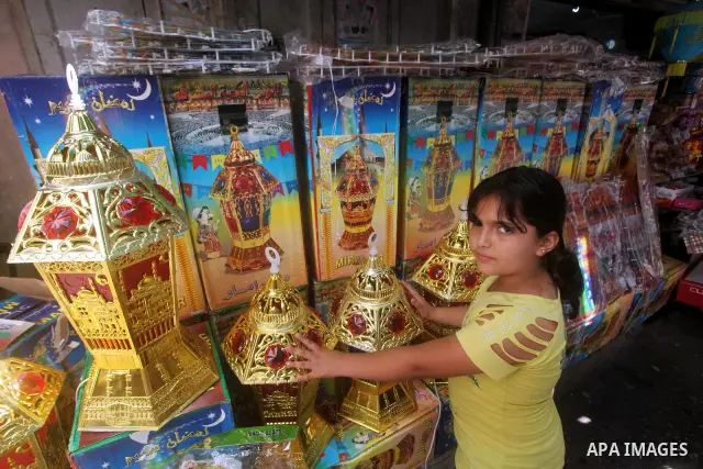 A Palestinian child Inspects toys as the vendor displays goods in preparation for the holy month of Ramadan in the Gaza city on July 17, 2012 . Islam's holy month of Ramadan will begin in few days depending on the sighti...