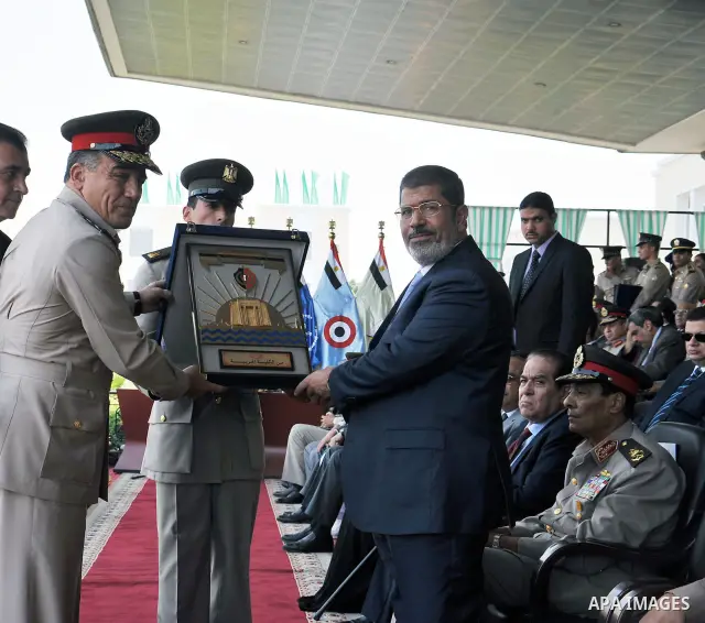 Egyptian President Mohamed Morsi honoring a military cadet during a medal ceremony for graduates at the Egyptian Military Academy in Cairo July 17, 2012. Sherif Abd Monam / Egyptian Presidency