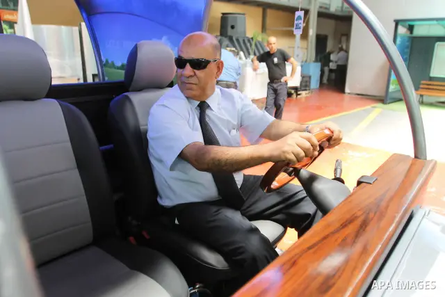 Palestinian staff member introduces the first Palestinian electric car to visitors during an international environment expo held in the West Bank city of Hebron, on 17 July 2012. The exhibitors attended the expo bringing...