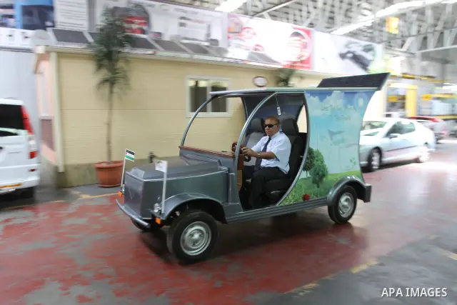 Palestinian staff member introduces the first Palestinian electric car to visitors during an international environment expo held in the West Bank city of Hebron, on 17 July 2012. The exhibitors attended the expo bringing...