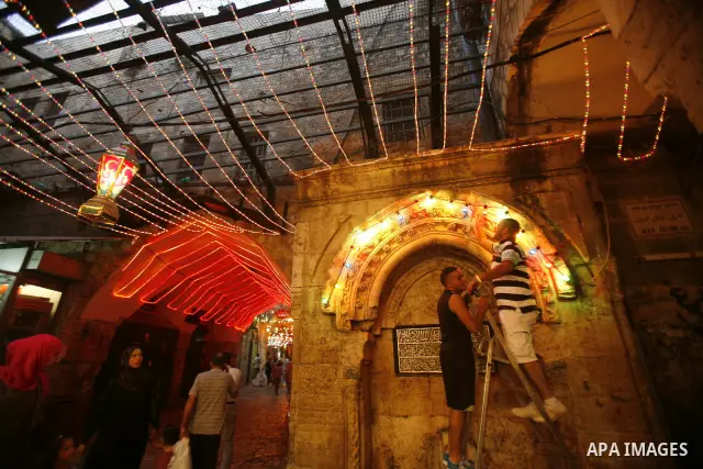 Palestinians hang up decorations before the Muslim holy month of Ramadan at a popular market in the old city of Jerusalem on July 17, 2012. The Muslim holy month of Ramadan begins Saturday 21 July , is traditionally dete...