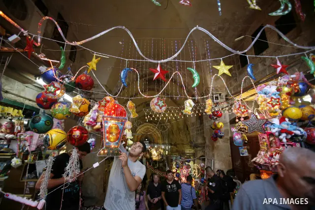 Palestinians hang up decorations before the Muslim holy month of Ramadan at a popular market in the old city of Jerusalem on July 17, 2012. The Muslim holy month of Ramadan begins Saturday 21 July , is traditionally dete...