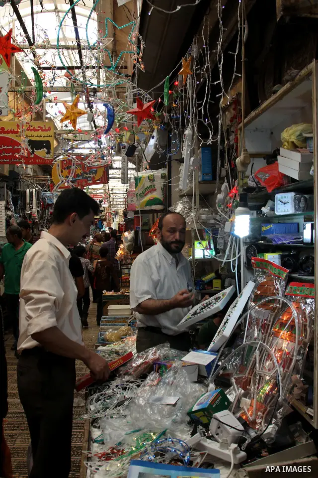 A Palestinian vendor decorates his shop with an electric crescent in preparation for the holy month of Ramadan in the West Bank city of Nablus, on July 18, 2012 . Islam's holy month of Ramadan will begin in few days depe...
