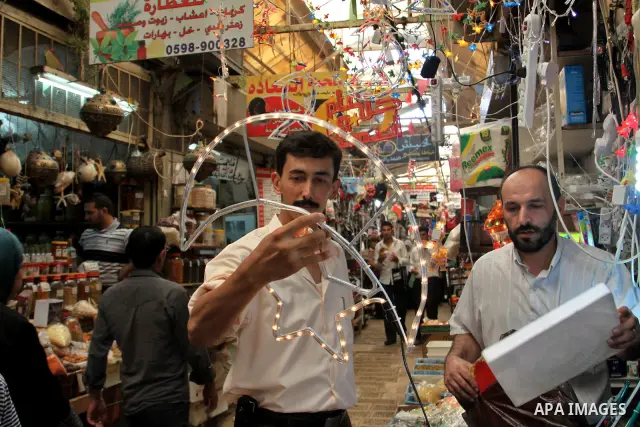 A Palestinian vendor decorates his shop with an electric crescent in preparation for the holy month of Ramadan in the West Bank city of Nablus, on July 18, 2012 . Islam's holy month of Ramadan will begin in few days depe...