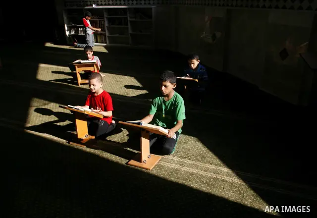 Palestinian boys read verses from the Quran during a class on how to save Islam's holy book, at a mosque in Rafah, southern Gaza city, on July 18, 2012. Photo by Eyad Al Baba