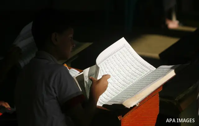 Palestinian boys read verses from the Quran during a class on how to save Islam's holy book, at a mosque in Rafah, southern Gaza city, on July 18, 2012. Photo by Eyad Al Baba