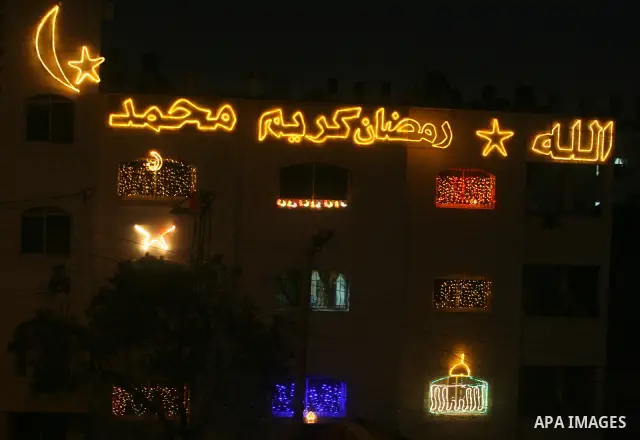 Palestinians hang up decorations before the Muslim holy month of Ramadan and write in Arabic, (Ramadan Karim) in their house in al-Bireh close to the West Bank city of Ramallah on July 18, 2012. The Muslim holy month of...