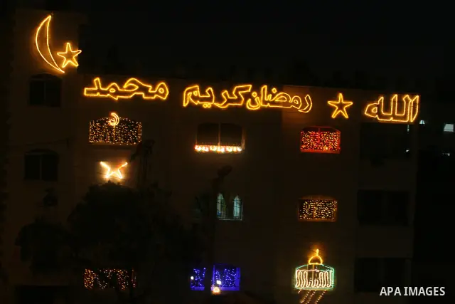 Palestinians hang up decorations before the Muslim holy month of Ramadan and write in Arabic, (Ramadan Karim) in their house in al-Bireh close to the West Bank city of Ramallah on July 18, 2012. The Muslim holy month of...