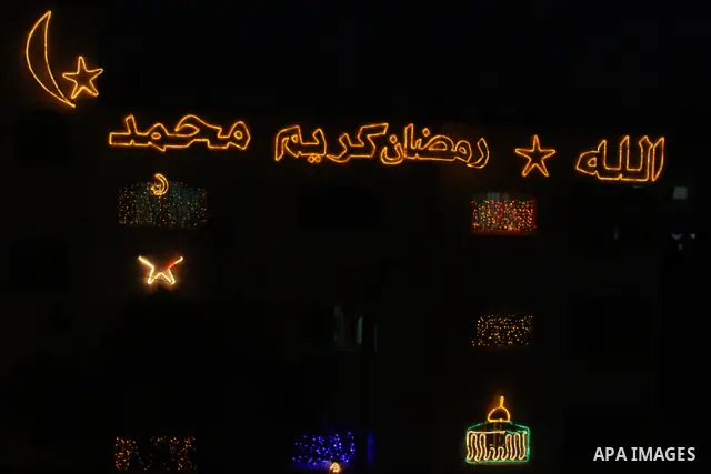Palestinians hang up decorations before the Muslim holy month of Ramadan and write in Arabic, (Ramadan Karim) in their house in al-Bireh close to the West Bank city of Ramallah on July 18, 2012. The Muslim holy month of...