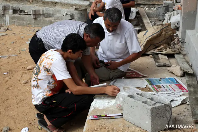 Palestinian secondary school students read a local newspaper to find their results in Gaza city on July 19, 2012. The Ministry of Education in Gaza Strip and the West Bank announced the results together. Photo by Ashraf...