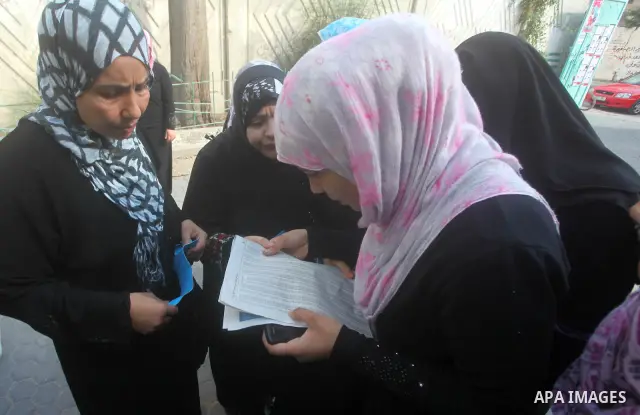 Palestinian secondary school students read a local newspaper to find their results in Gaza city on July 19, 2012. The Ministry of Education in Gaza Strip and the West Bank announced the results together. Photo by Ashraf...