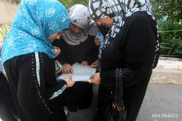 Palestinian secondary school students read a local newspaper to find their results in Gaza city on July 19, 2012. The Ministry of Education in Gaza Strip and the West Bank announced the results together. Photo by Ashraf...