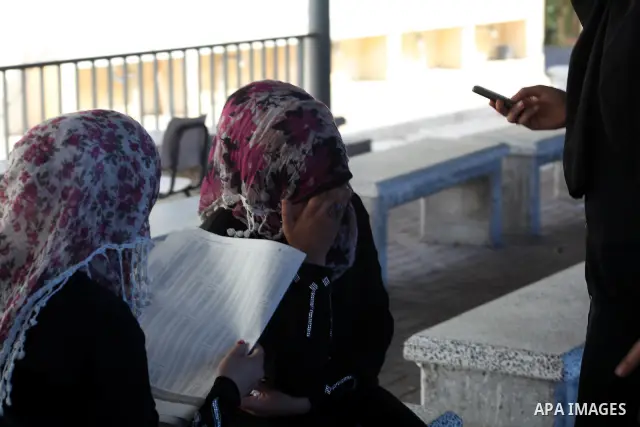 Palestinian secondary school students read a local newspaper to find their results in Gaza city on July 19, 2012. The Ministry of Education in Gaza Strip and the West Bank announced the results together. Photo by Ashraf...