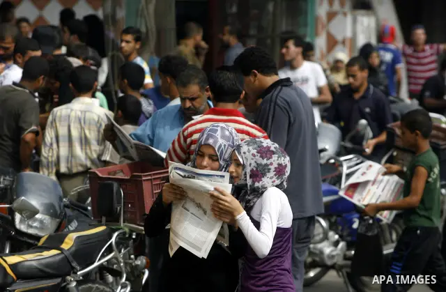 Palestinian secondary school students read a local newspaper to find their results in Rafah in the southern Gaza Strip on July 19, 2012. The Ministry of Education in Gaza Strip and the West Bank announced the results tog...