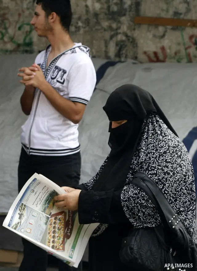 Palestinian relatives students read a local newspaper to find their results in Rafah in the southern Gaza Strip on July 19, 2012. The Ministry of Education in Gaza Strip and the West Bank announced the results together....