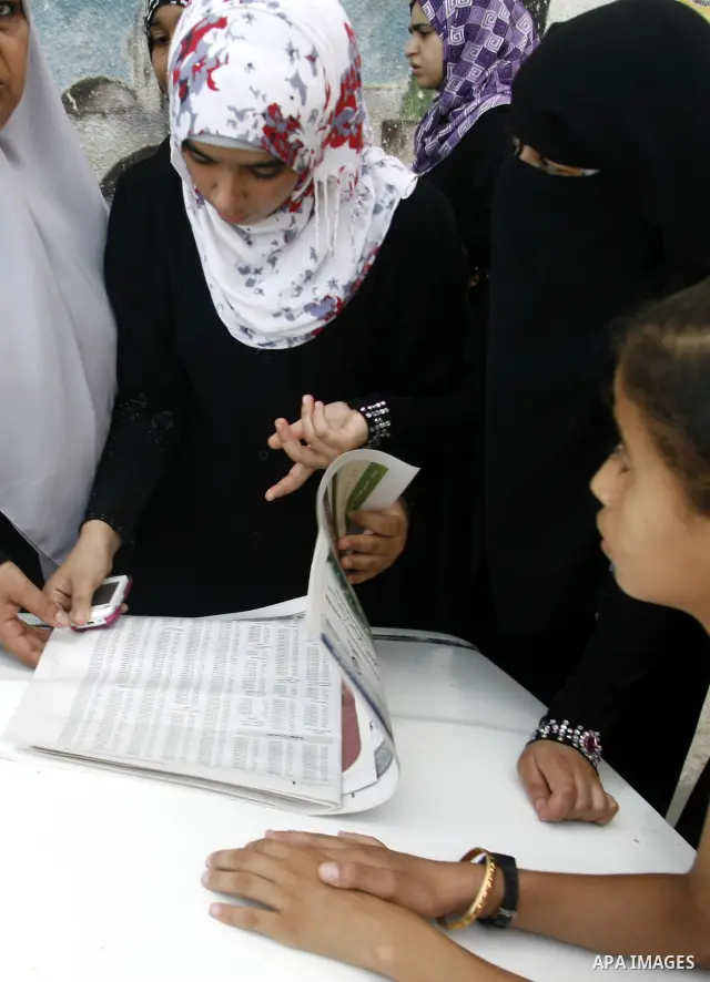 Palestinian secondary school students read a local newspaper to find their results in Rafah in the southern Gaza Strip on July 19, 2012. The Ministry of Education in Gaza Strip and the West Bank announced the results tog...