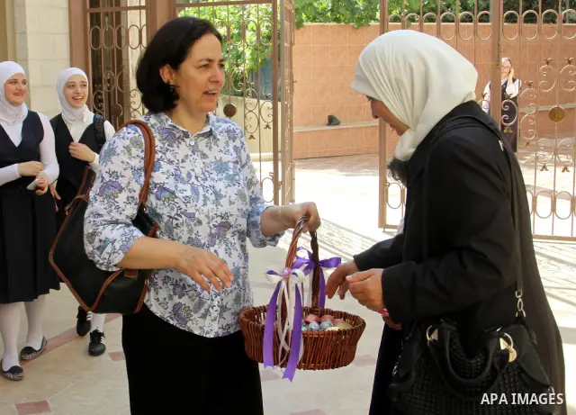 A Palestinian woman gives candy after heard the results of final exams of her high school daughter known as "Tawjihi" in the West Bank city of Nablus, on July 19, 2012. The Ministry of Education in Gaza Strip announced t...