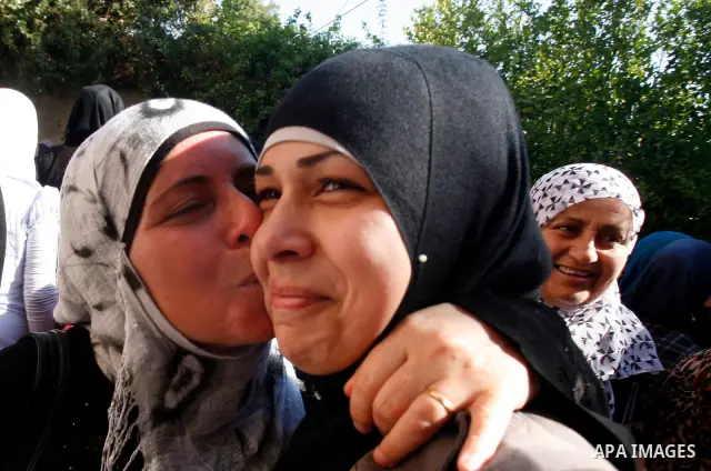 A Palestinian woman kiss her high school daughter after heard the results of final exams known as "Tawjihi" in Jerusalem, on July 19, 2012. The Ministry of Education in Gaza Strip announced the final results coincide wit...