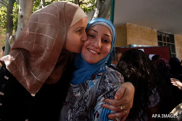 Palestinian high school students take hug after heard their results of final exams known as "Tawjihi" in Jerusalem, on July 19, 2012. The Ministry of Education in Gaza Strip announced the final results coincide with the...