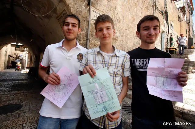 Palestinian high school students show the results of their final exams known as "Tawjihi" in Jerusalem, on July 19, 2012. The Ministry of Education in Gaza Strip announced the final results coincide with the West Bank. P...